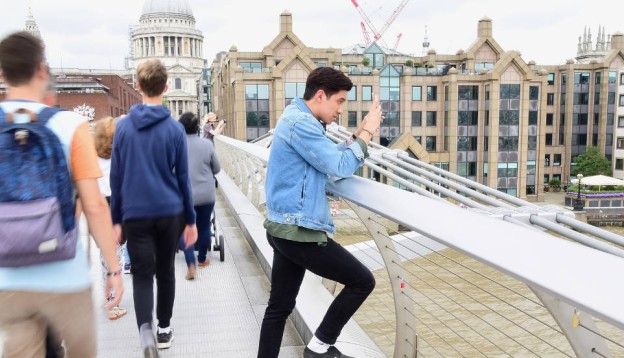 Boy taking a picture on Millenium Bridge london