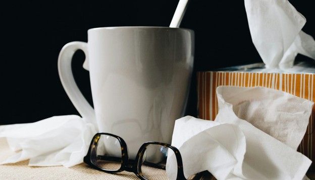 tissues and cup of tea signifying a cold/flu