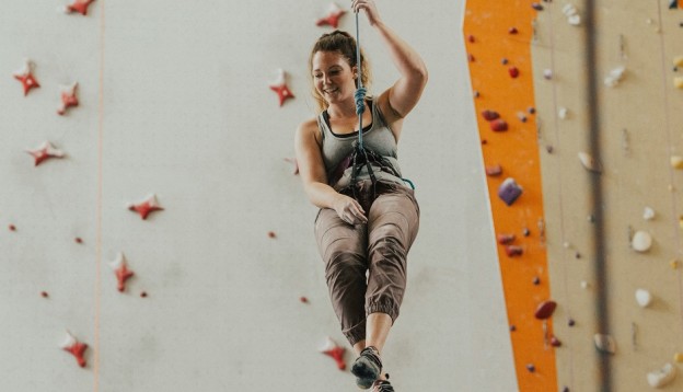 Woman abseiling at indoor climbing centre